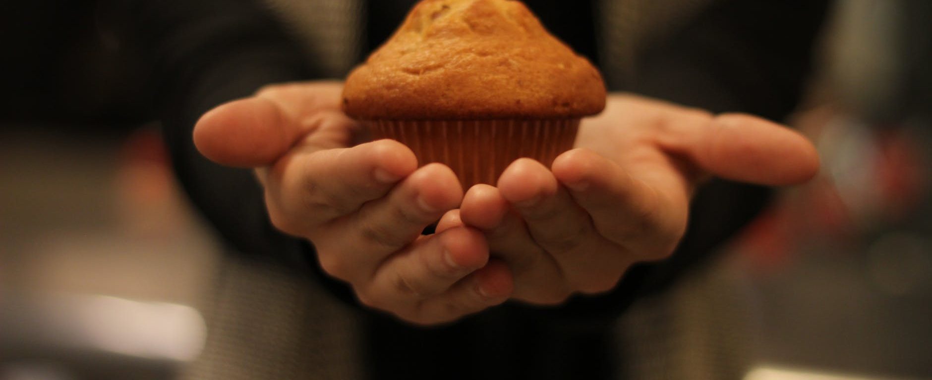 person s hand with cupcake