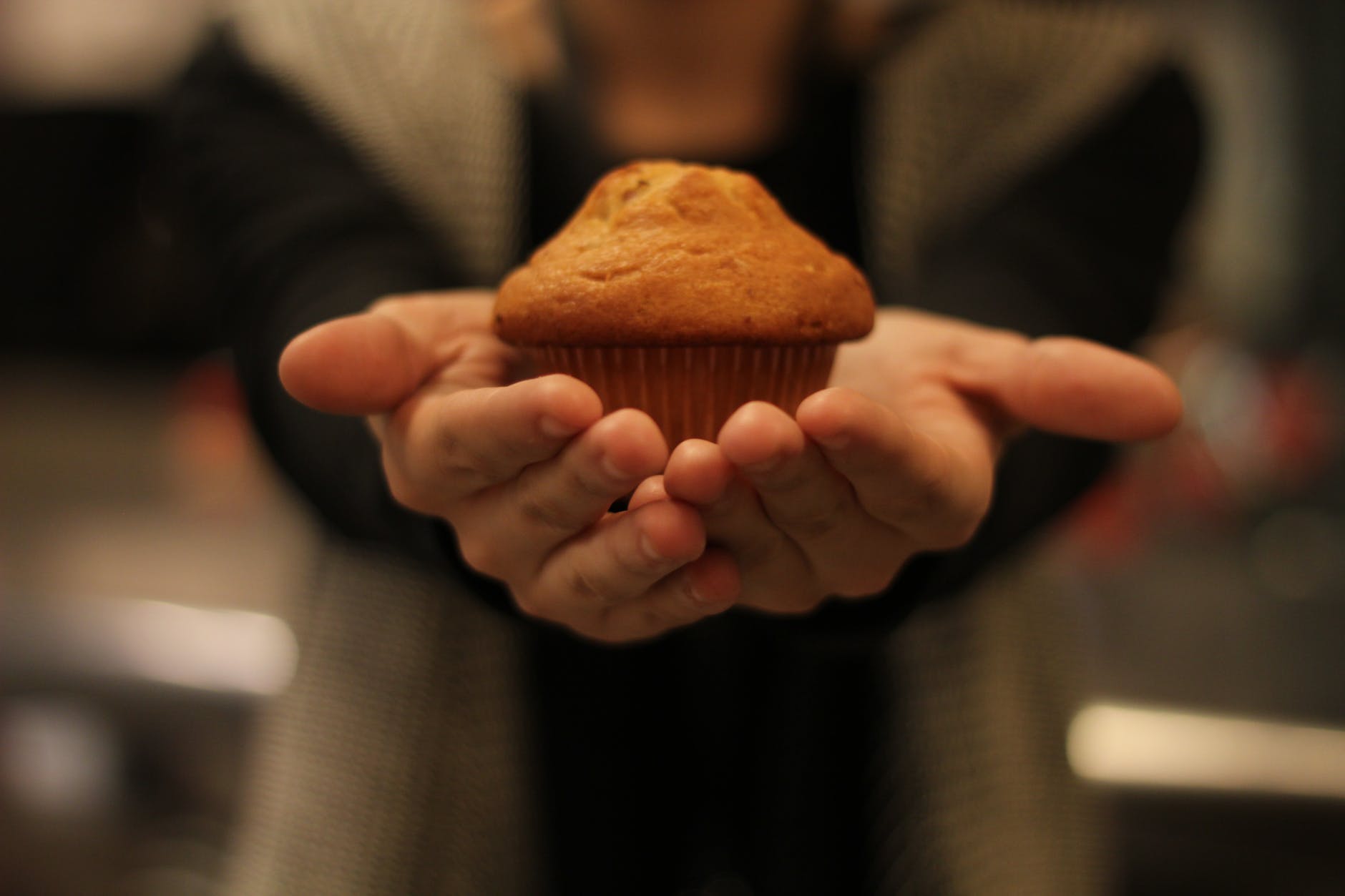 person s hand with cupcake