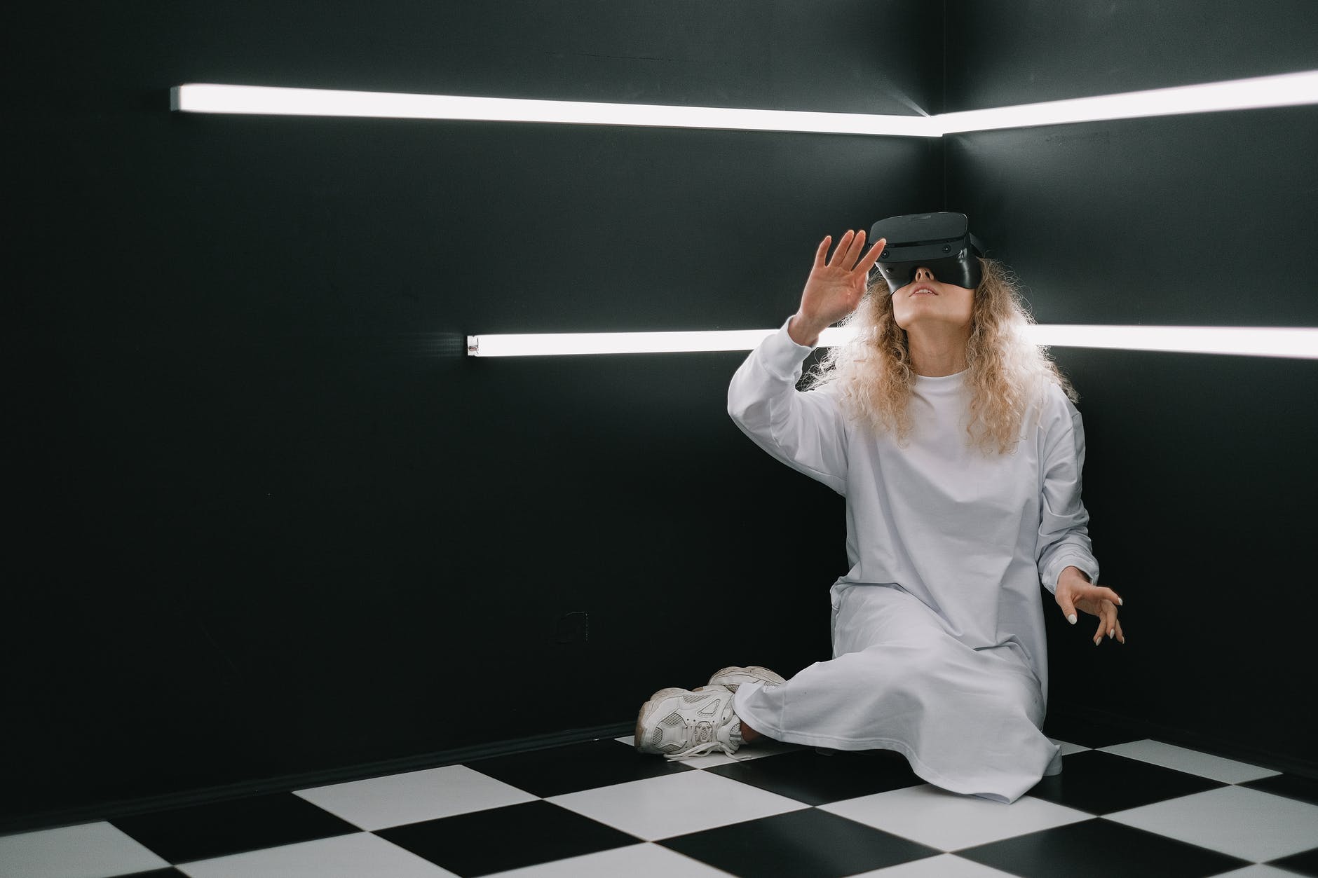 a woman in a white dress using a vr goggles