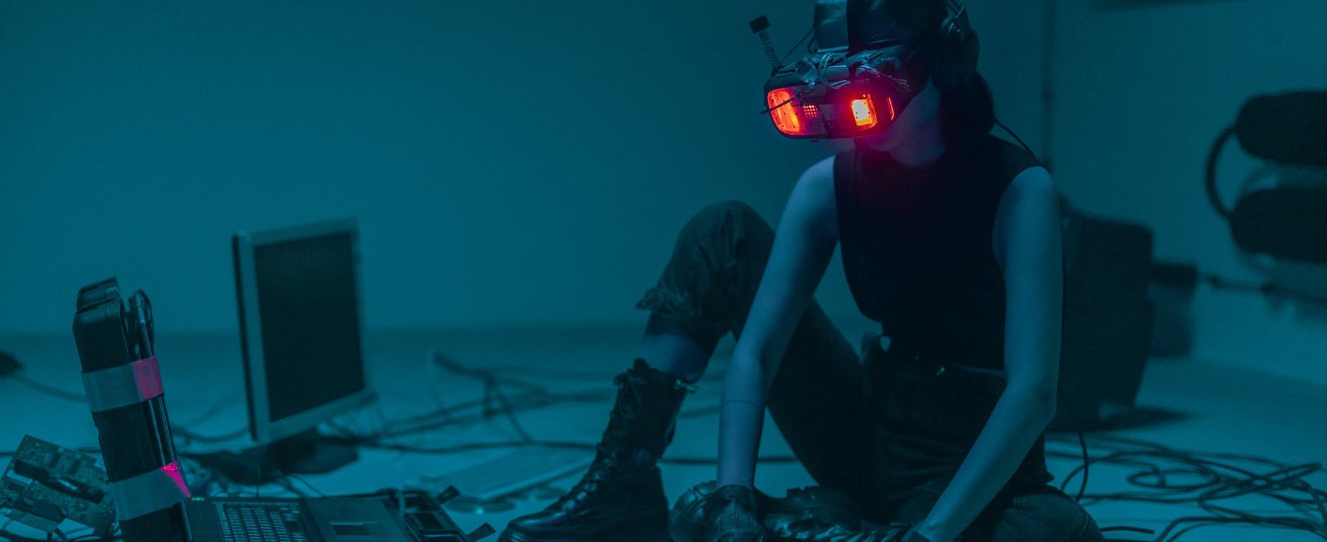 a person sitting on the floor with vr goggles using a computer