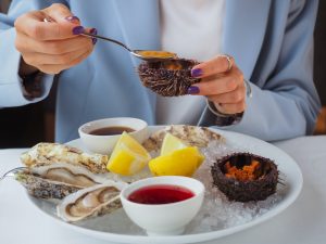 close up of woman eating oysters in restaurant