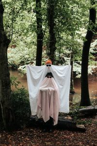 people dressed up as ghosts in the forest
