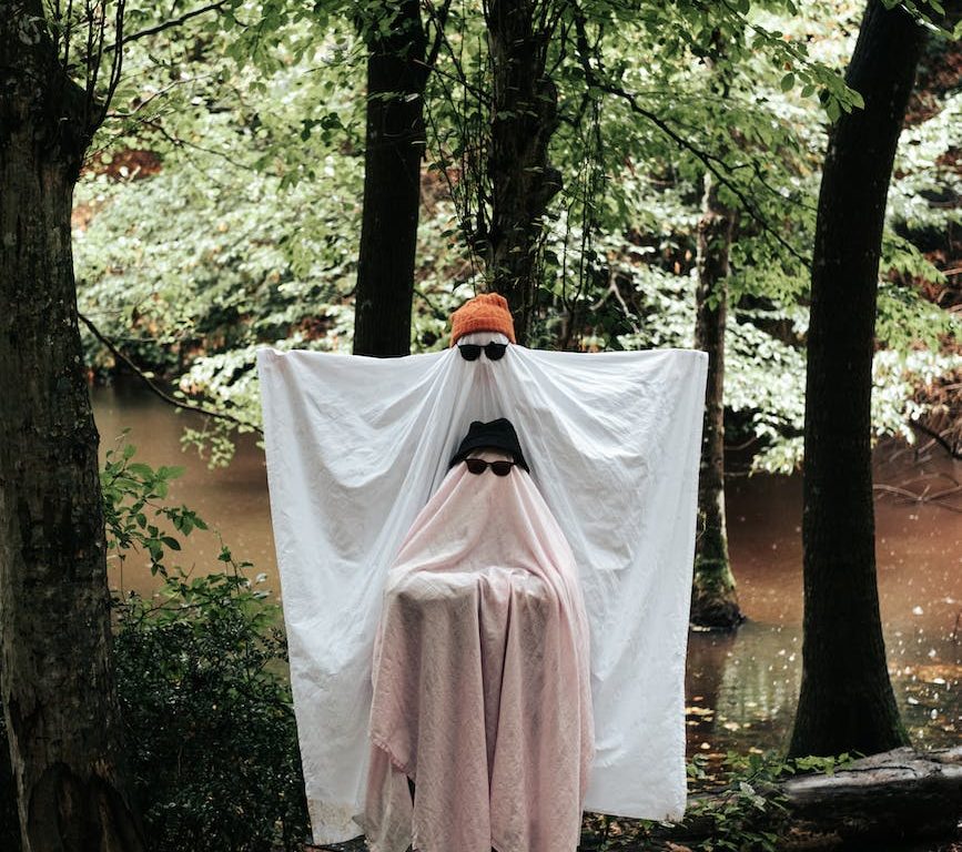 people dressed up as ghosts in the forest