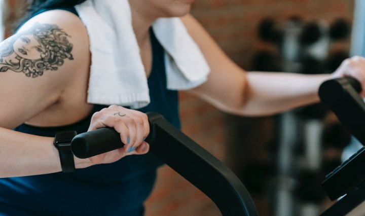 young woman doing exercises on cycling machine