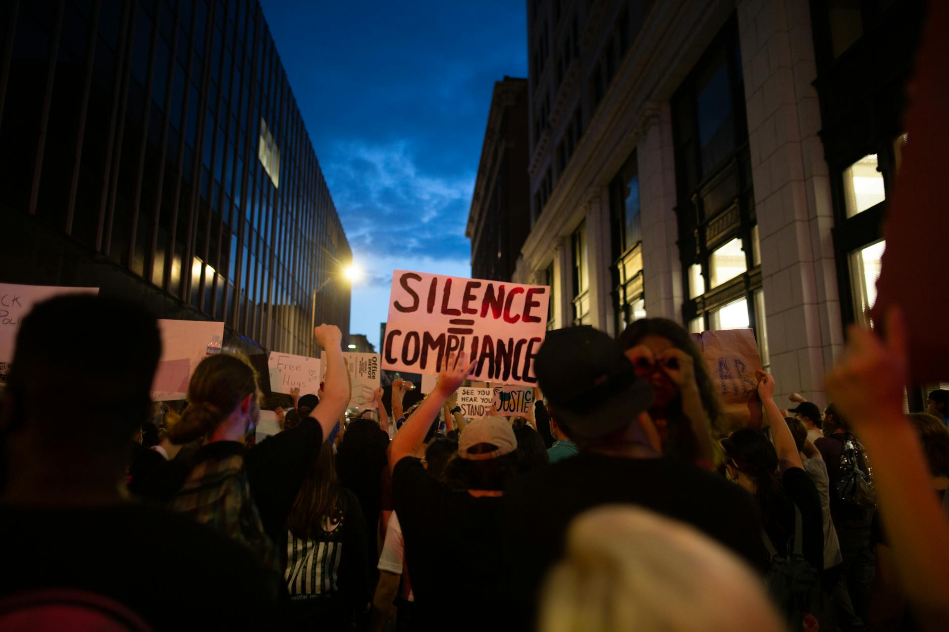 crowd of activists with raised arms and placards on street