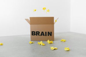 brain inscription on cardboard box under flying paper pieces