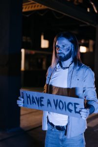 man standing and holding a protest sign
